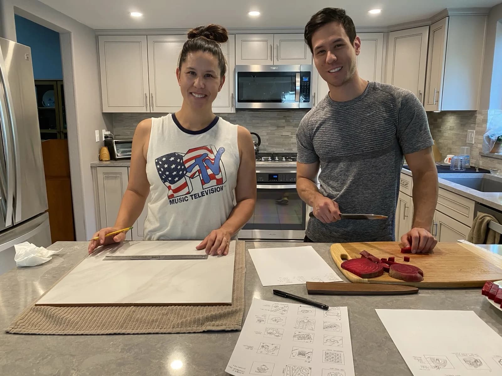 Amie and Adam Watanabe planning a sushi shoot at the kitchen counter, with storyboard sketches and sliced beets on a cutting board